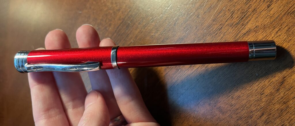 A red sparkly pen with silver hardware. 