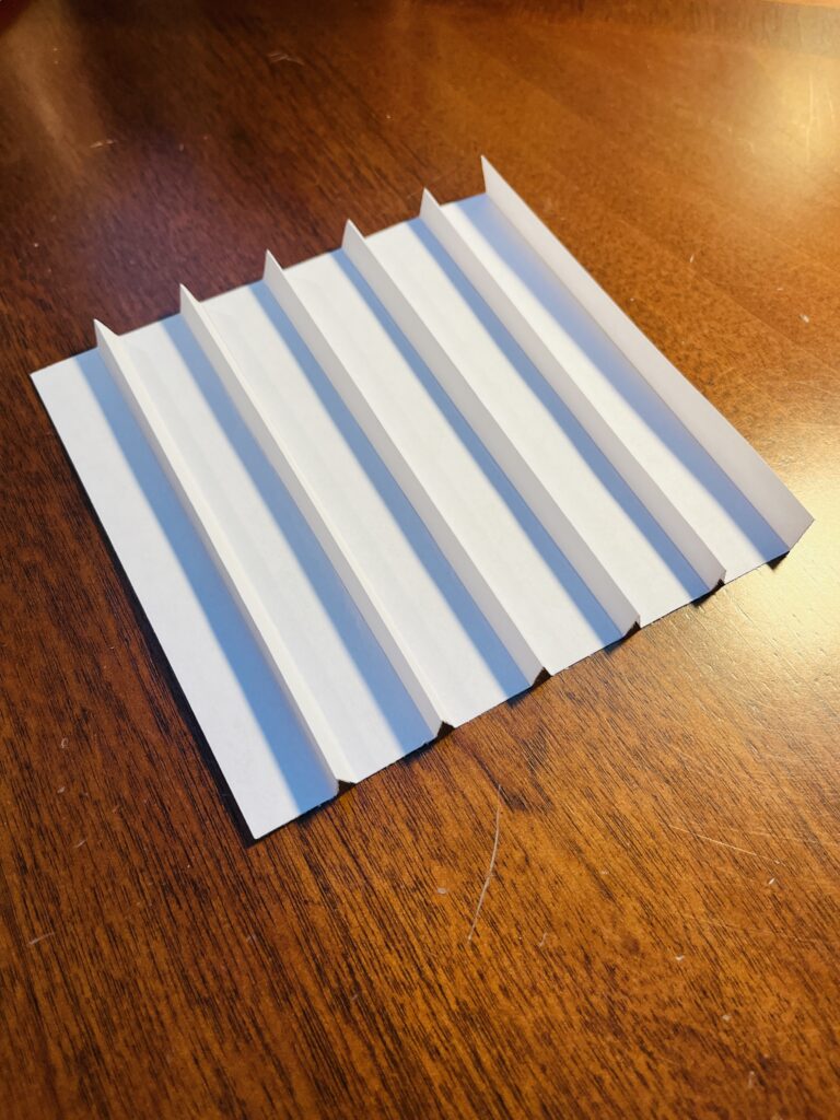 Half a piece of paper, flat on the table, with folded dividers, the folds are slightly separated.