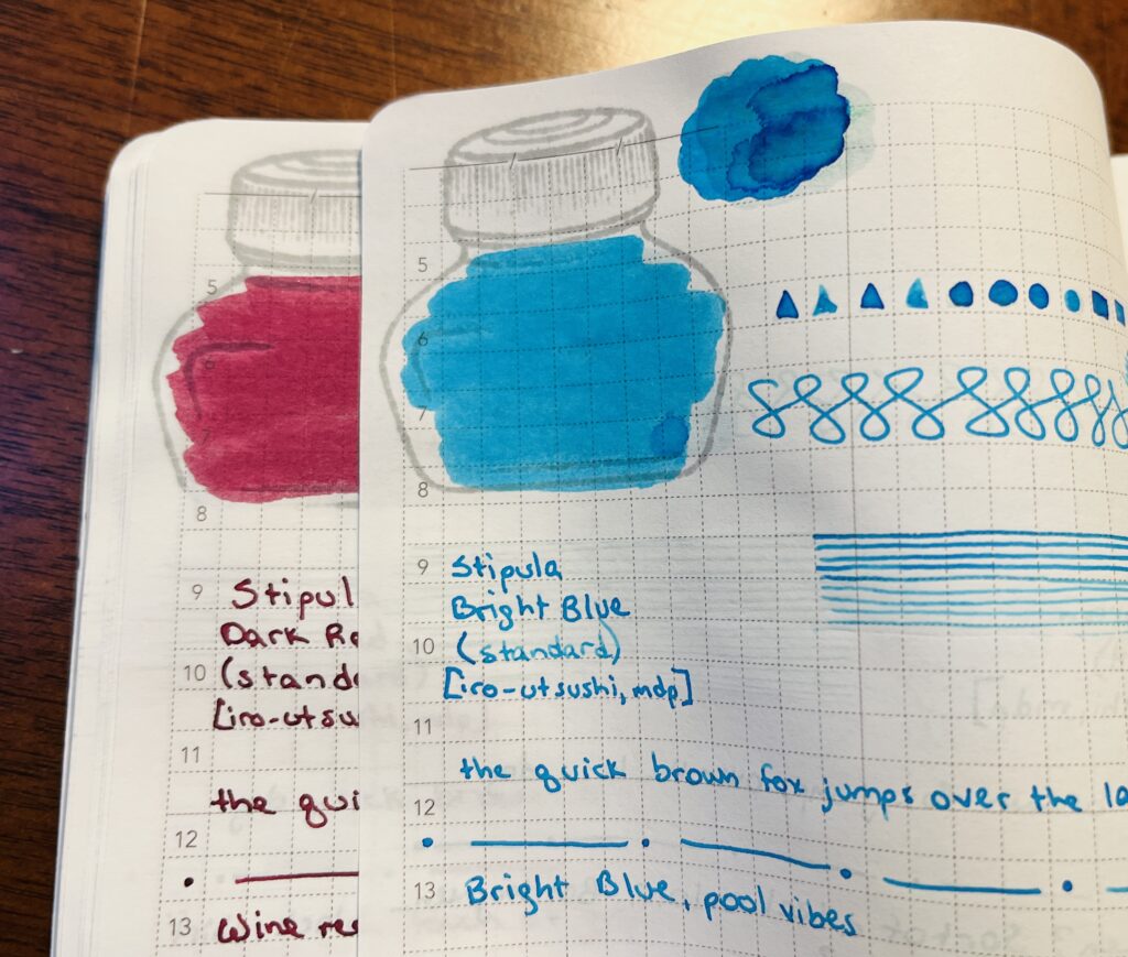 The edges of two pages in a journal. Each page has samples of a single ink, a dark red, and a bright blue. Only the edge of the ink bottle mark and the lines drawn are visible on one of the pages. The top page, Bright Blue, you can see the geometric shapes, ink pool, ink bottle color in, straight lines, the end of the phrase “the quick brown fox jumps over the last dog” then a page separator of a straight line followed by a dot repeated, and then thoughts on the ink.