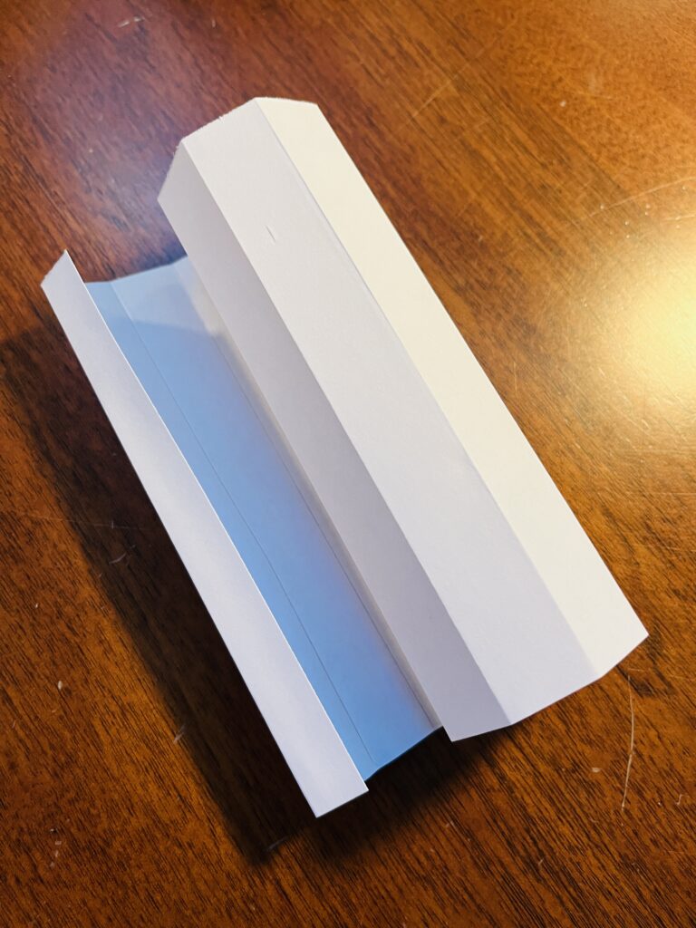 Half a piece of white paper folded and curled up by the folds.