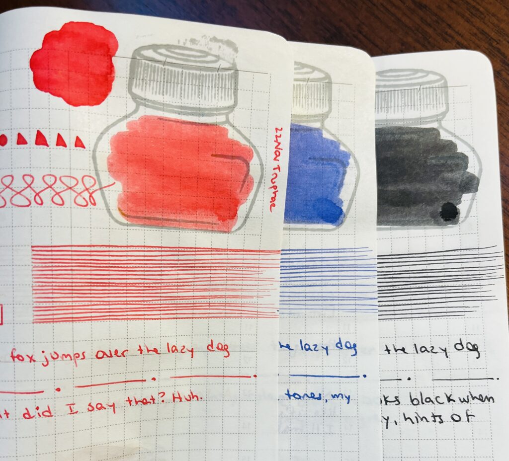 3 notebook pages overlapping each other, able to see just a portion of the bottom 2 pages, and more of the top page. There is a red, a blue, and a black ink sampled with shapes, swirls, straight lines, smudges and writing. 